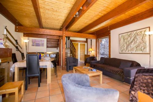 un soggiorno con un divano e un tavolo di Chalet Résidence Chantey Mourry 67 - Happy Rentals a Chamonix-Mont-Blanc