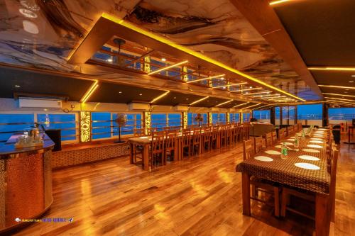 een eetkamer met tafels en stoelen op een schip bij Karimeen Boathouse in Alleppey