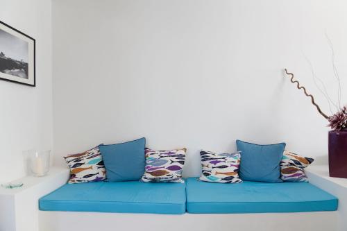 a blue couch with pillows in a living room at Hotel Cutimare - Aeolian Charme in Acquacalda