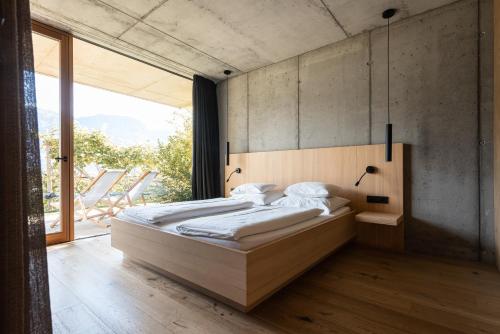 una camera da letto con due letti e una grande finestra di Füchslhof a Marlengo