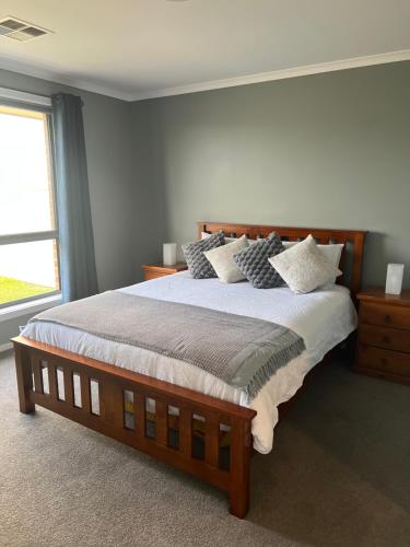a bedroom with a large bed and a window at Telopea House Mount Gambier in Worrolong