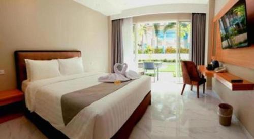 Rama Garden Hotel في بالو: غرفة فندقية بها سرير كبير ومكتب