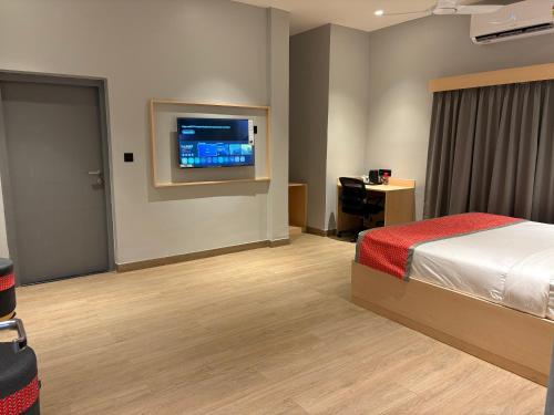 a hotel room with a bed and a flat screen tv at The Citi Residenci Hotel, Bidhannagar in Durgāpur