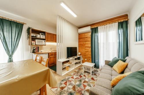 a living room with a couch and a tv at EntreVales Serra da Estrela in Penhas da Saúde