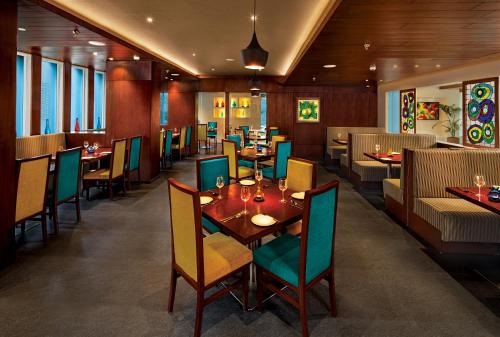 une salle à manger avec des tables et des chaises dans un restaurant dans l'établissement Lemon Tree Hotel, Vadodara, à Vadodara