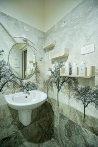 a bathroom with a sink and a mirror at SaffronStays Oakridge Cottage in Coonoor