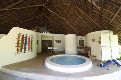 a large room with a hot tub in a building at Unguja Lodge in Kizimkazi