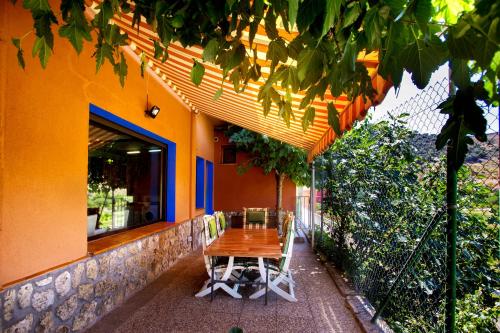 a wooden table and chairs sitting outside of a building at Suite Rural Carenas in Carenas