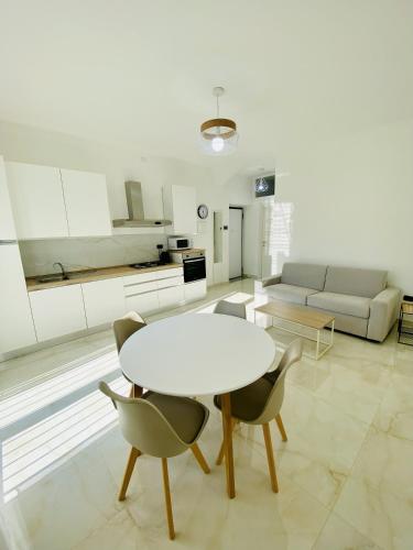 un salon avec une table et des chaises blanches dans l'établissement Corso 42, à Novara