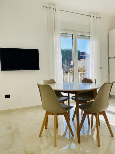 une salle à manger avec une table et des chaises et une télévision dans l'établissement Corso 42, à Novara