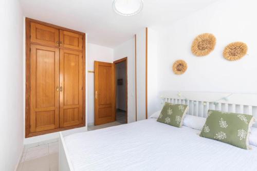 a bedroom with a white bed and a wooden door at apartamento Cabo de Gata in El Cabo de Gata