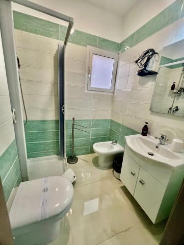 a bathroom with a toilet and a sink and a shower at Affittacamere La bottega del barbiere in Scalea