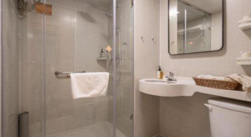a bathroom with a shower and a sink and a toilet at Jinjiang Inn Hangzhou Lin'an Qianwang Street in Lin'an