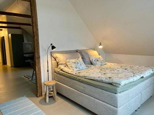 Una cama grande en una habitación con un taburete pequeño. en Nygård Apartments, en Klagstorp