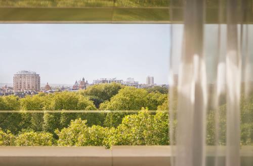 a window with a view of a city at 45 Park Lane - Dorchester Collection in London