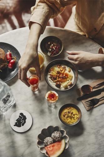 una persona sentada en una mesa con platos de comida en Hotel Frantz, WorldHotels Crafted, en Estocolmo