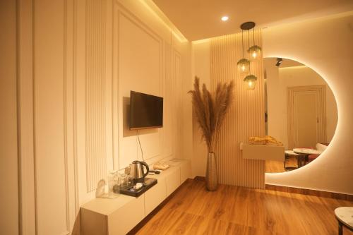 a living room with a table and a tv on a wall at Meghnad By Padmaraag in Nalbāri