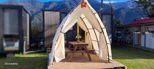 una tenda triangolare con un tavolo di legno in un cortile di Cloudview Cottages by Tiny Away a Huan-shan