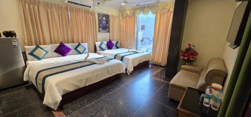 Una habitación de hotel con dos camas y una ventana. en Hotel KCR, en Srikalahasti