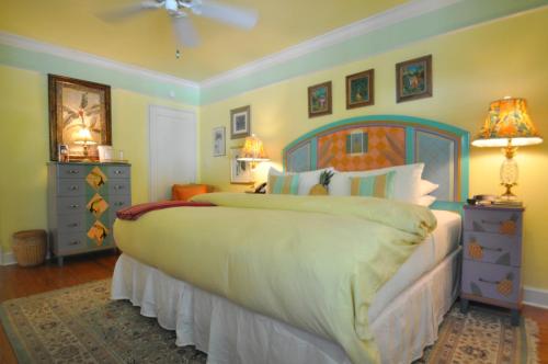 a bedroom with a large bed with a blue headboard at Pineapple Point Guesthouse & Resort - Gay Men's Resort in Fort Lauderdale