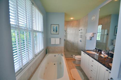 La salle de bains est pourvue d'une baignoire, de toilettes et d'un lavabo. dans l'établissement Pineapple Point Guesthouse & Resort - Gay Men's Resort, à Fort Lauderdale