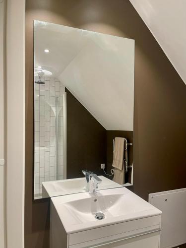 a bathroom with a sink and a large mirror at Nygård Apartments in Klagstorp