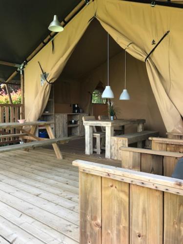 een tent met een bar en een tafel in een kamer bij Camping Le Mondou in Saint-Julien-de-Lampon