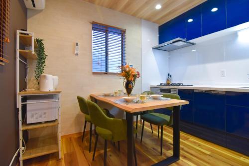 a kitchen with a wooden table and green chairs at MARIO House - Free Parking- in Osaka