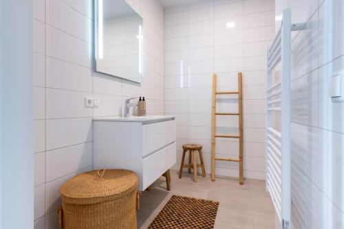 un baño con lavabo y taburete en Luxe apartment in recidence marina uithaven 1C, en Kamperland