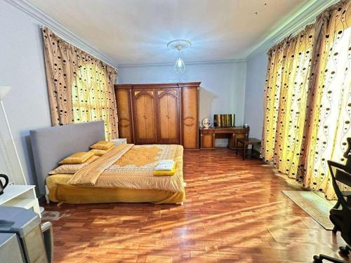 a bedroom with a bed and a wooden floor at Villa Terrace Master Room Abu Dhabi 2nd floor in Abu Dhabi