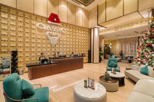 Un vestíbulo de un hotel clásico con un árbol de Navidad. en CLASSYC Hotel, en Hanói