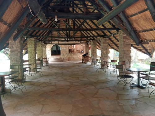 Una gran sala con mesas y sillas en un edificio. en Chirundu - Zambezi River Campsite & Swimming Pool & WiFi, en Chirundu