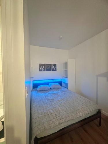 Schlafzimmer mit einem Bett mit blauem Licht in der Unterkunft The Urban Refuge in Champs-Sur-Marne