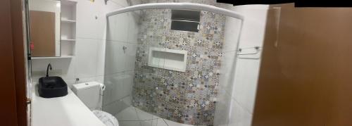 e bagno con servizi igienici e tenda doccia a mosaico. di Casa com piscina e área kids a Serra