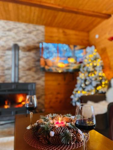 a table with a christmas tree and glasses of wine at Mountain houses Milovanovic in Žabljak