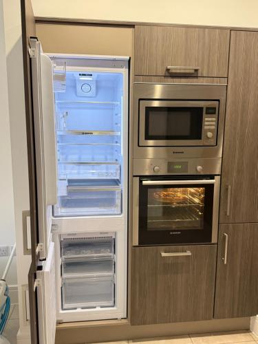un frigorifero aperto con la porta aperta e un forno di Modern 3-Bedroom Home in Bletchley, Milton Keynes a Bletchley