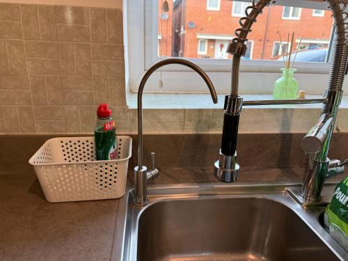 un lavandino con rubinetto accanto a un lavandino di Modern 3-Bedroom Home in Bletchley, Milton Keynes a Bletchley