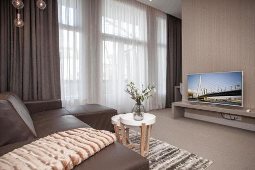a living room with a couch and a tv at Maurits Apartments & Suites in Rotterdam