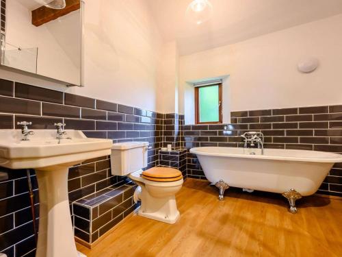 a bathroom with a tub and a toilet and a sink at 3 Bed in Cockermouth oc-88773 in Buttermere