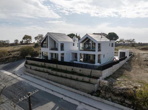 a white house sitting on the side of a road at Pamboo TerraVine House by Nomads in Statos and Ayios Photios