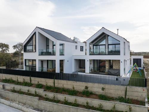 a white house on the side of a road at Pamboo TerraVine House by Nomads in Statos and Ayios Photios