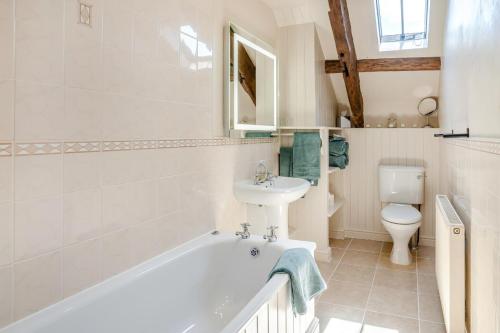 a bathroom with a tub and a sink and a toilet at 1 Bed in Nantygwreiddyn oc-bow49 in Sennybridge