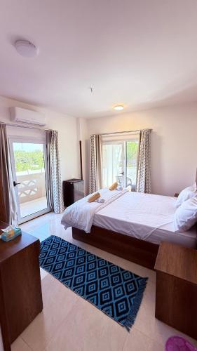 a bedroom with a large bed and a large window at Magic Garden House in Luxor