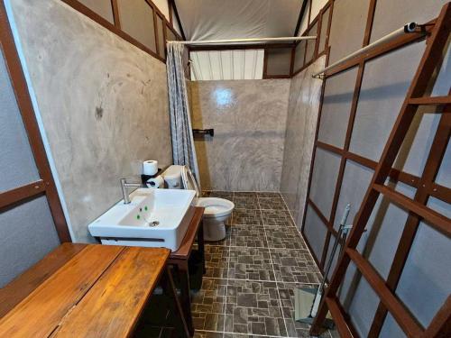 a bathroom with a white sink and a toilet at Phayam Local homestay in Ko Phayam