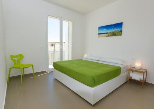 een slaapkamer met een bed en een stoel erin bij Appartamenti Sud Est in Marina di Ragusa