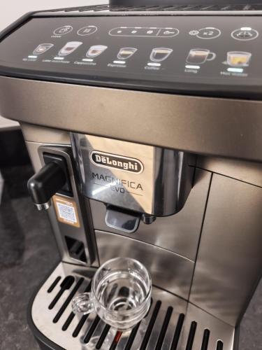 a coffee espresso machine with a cup in thevisor at Coração de Viana AL in Viana do Castelo
