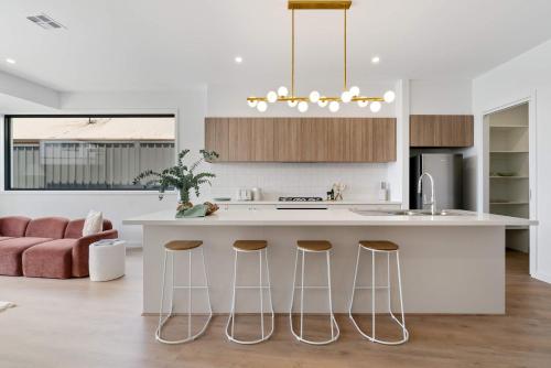 een keuken met een groot eiland met barkrukken bij Poolside Luxury Villa - Solar Pool Beach 3min in Mornington