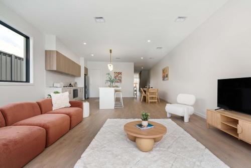 a living room with a couch and a table at Poolside Luxury Villa - Solar Pool Beach 3min in Mornington