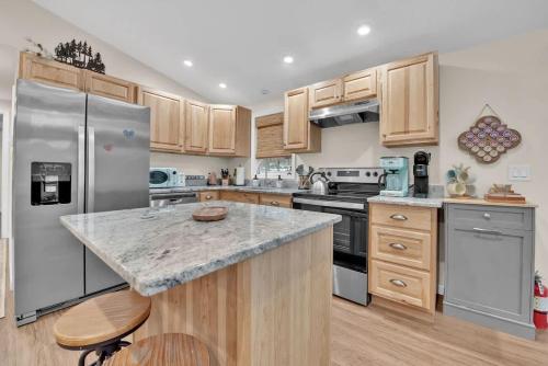 eine Küche mit Küchengeräten aus Edelstahl und Holzschränken in der Unterkunft A Refined Retreat Perfect for Couples or Families in Westcolang Park