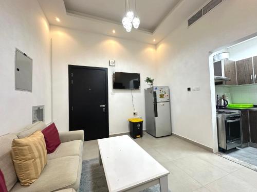 a living room with a couch and a refrigerator at Entire Studio Apartment Beside Oasis towers in Ajman 